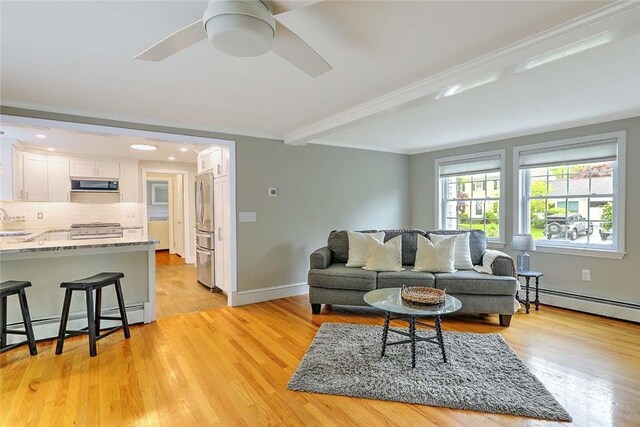 15 Lafayette Rd, Barrington, RI 02806 - living area with a baseboard heating unit, light wood-style floors, a ceiling fan, ornamental molding, and baseboards