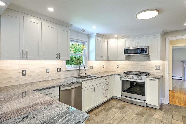 15 Lafayette Rd, Barrington, RI 02806 - kitchen with appliances with stainless steel finishes, a sink, a baseboard radiator, light stone counters, and white cabinetry