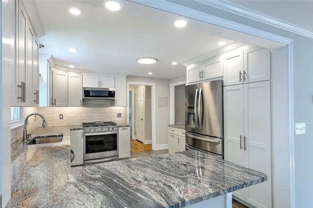 15 Lafayette Rd, Barrington, RI 02806 - kitchen with appliances with stainless steel finishes, a sink, backsplash, light stone countertops, and baseboards