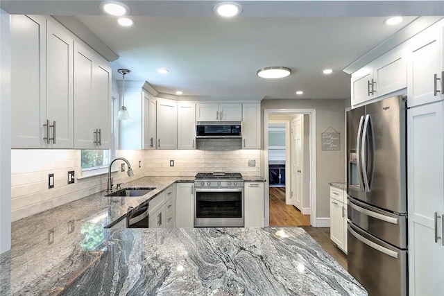 15 Lafayette Rd, Barrington, RI 02806 - kitchen with appliances with stainless steel finishes, a sink, light stone countertops, wood finished floors, and white cabinetry