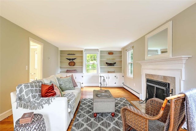 15 Lafayette Rd, Barrington, RI 02806 - living room featuring a baseboard heating unit, light wood finished floors, a fireplace with flush hearth, baseboards, and built in shelves