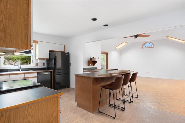 3 Ernest St, Newport, RI 02840 - kitchen with black appliances, a kitchen breakfast bar, a sink, ceiling fan, and plenty of natural light