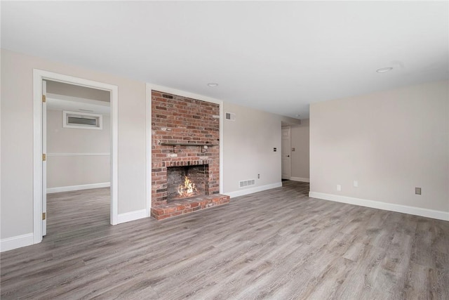 3 Ernest St, Newport, RI 02840 - unfurnished living room with wood finished floors, a brick fireplace, baseboards, and recessed lighting