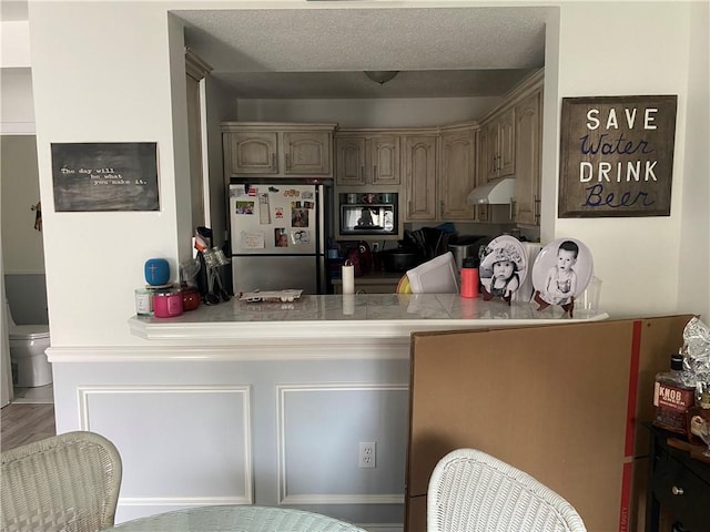 223 High St Unit S, Westerly, RI 02891 - kitchen with freestanding refrigerator, under cabinet range hood, and a peninsula