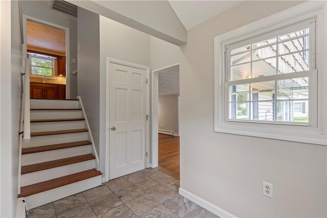 19 Bruce Dr, North Smithfield, RI 02896 - stairway featuring baseboards, stone tile flooring, lofted ceiling, and a baseboard heating unit