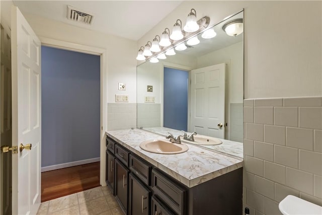 19 Bruce Dr, North Smithfield, RI 02896 - bathroom with tile walls, vanity, toilet, and a wainscoted wall