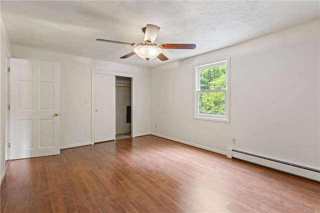 19 Bruce Dr, North Smithfield, RI 02896 - unfurnished bedroom featuring a baseboard radiator, wood finished floors, baseboards, a closet, and ceiling fan