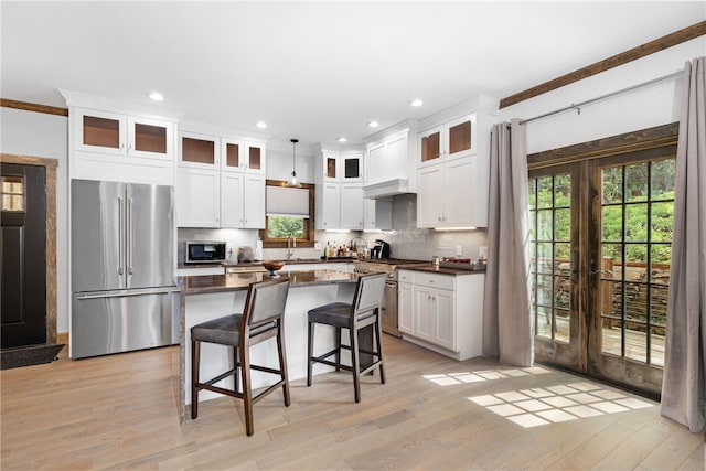 3 Gardenia Dr Unit M6, Richmond, RI 02898 - kitchen featuring premium appliances, white cabinets, a breakfast bar, tasteful backsplash, and french doors