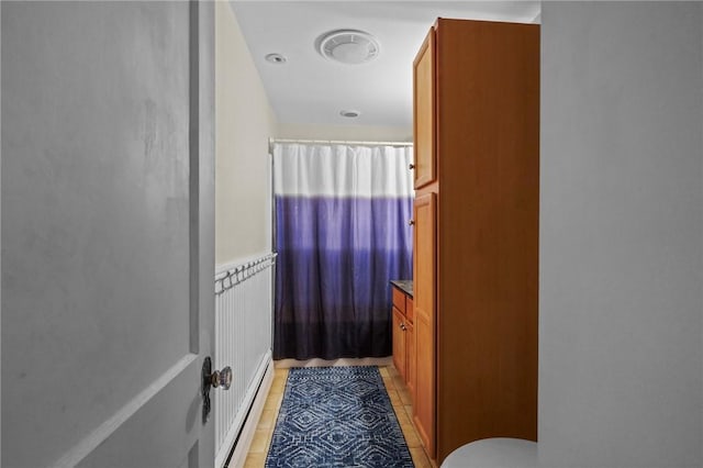 47 Cliff St, East Greenwich, RI 02818 - full bathroom featuring a baseboard heating unit, a shower with curtain, toilet, vanity, and tile patterned flooring