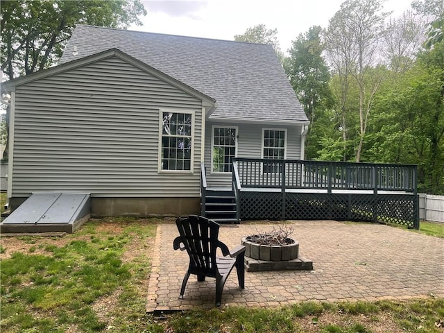 54 Polk Rd, Warwick, RI 02889 - back of property featuring an outdoor fire pit, a deck, a patio, and roof with shingles