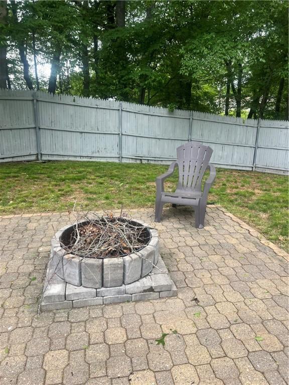 54 Polk Rd, Warwick, RI 02889 - fenced backyard with an outdoor fire pit and a patio