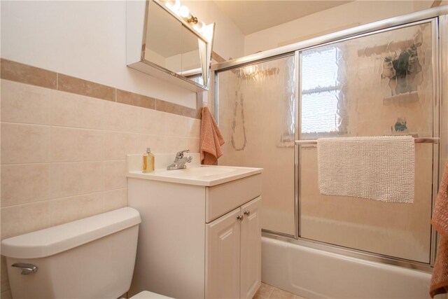 70 Carroll Ave Unit 510, Newport, RI 02840 - bathroom featuring tile walls, toilet, vanity, and shower / bath combination with glass door