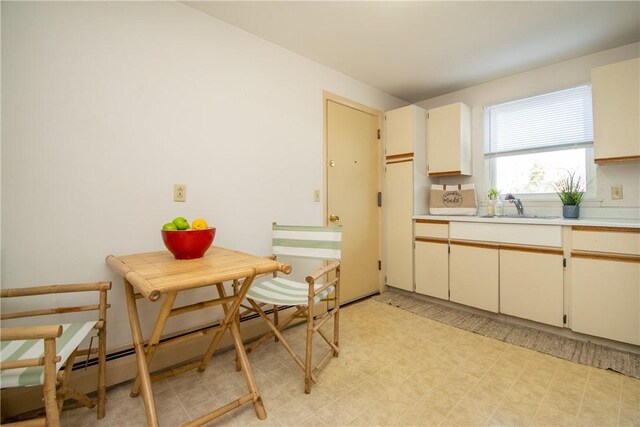 70 Carroll Ave Unit 510, Newport, RI 02840 - kitchen featuring a sink, a baseboard heating unit, light flooring, light countertops, and cream cabinetry