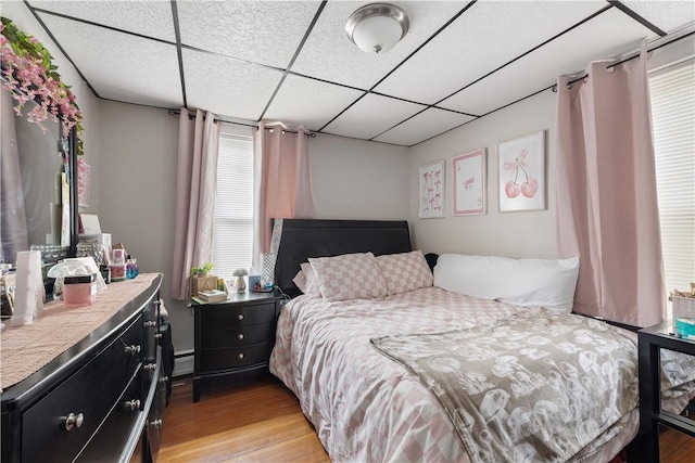 23 Auburn St, Pawtucket, RI 02860 - bedroom featuring light wood-style flooring, a paneled ceiling, and a baseboard radiator