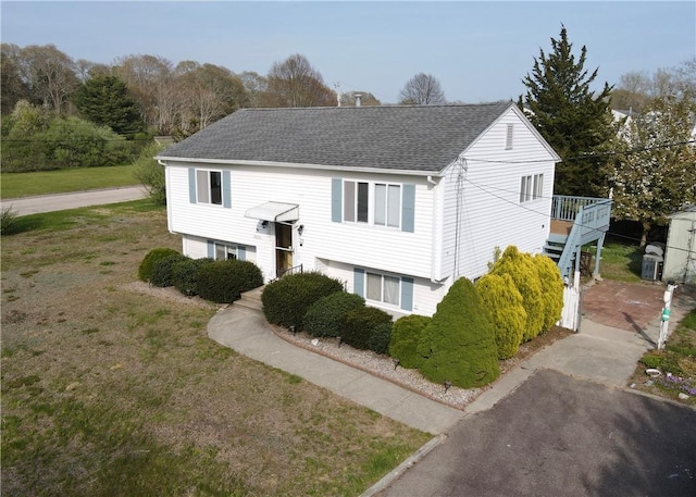 22 Sandy Ln, Westerly, RI 02891 - raised ranch with a shingled roof, a deck, and a front lawn