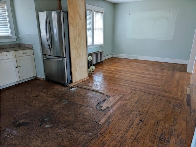 33 Zella St, Providence, RI 02908 - kitchen featuring freestanding refrigerator, radiator heating unit, white cabinetry, and baseboards