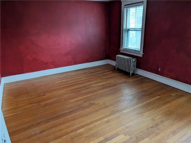33 Zella St, Providence, RI 02908 - empty room featuring radiator heating unit, wood finished floors, and baseboards