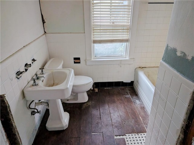 33 Zella St, Providence, RI 02908 - bathroom with tile walls, toilet, hardwood / wood-style flooring, a tub, and wainscoting