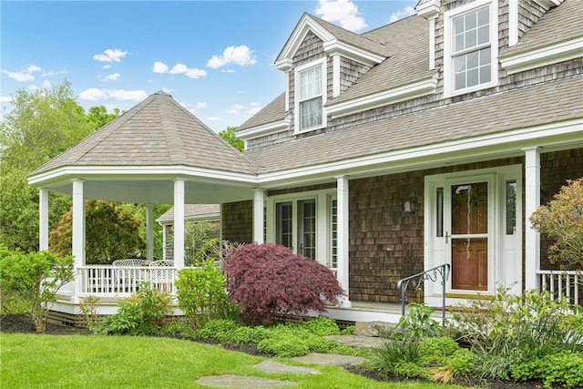 576 W Main Rd, Little Compton, RI 02837 - view of front of house with covered porch, a shingled roof, and a front lawn