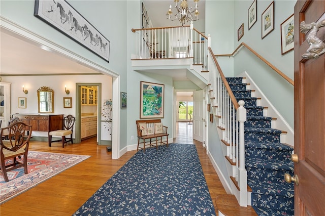 576 W Main Rd, Little Compton, RI 02837 - foyer featuring a chandelier, wood finished floors, stairs, baseboards, and a towering ceiling