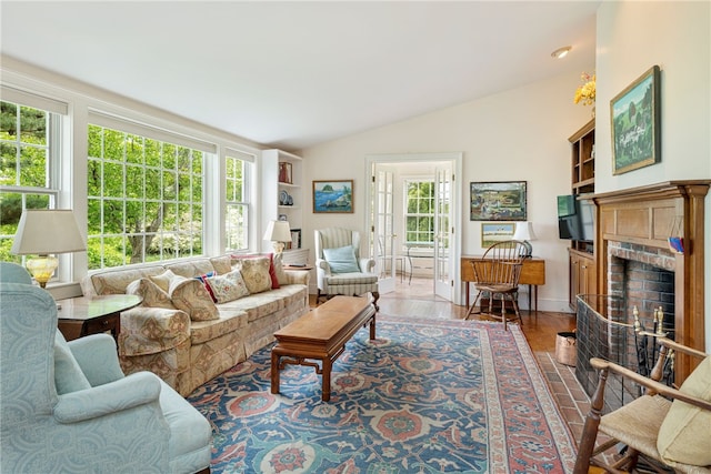 576 W Main Rd, Little Compton, RI 02837 - living room featuring a brick fireplace, vaulted ceiling, and wood finished floors