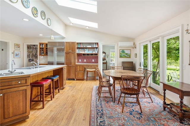 576 W Main Rd, Little Compton, RI 02837 - dining area with a wall mounted AC, a skylight, vaulted ceiling, light wood-style floors, and recessed lighting