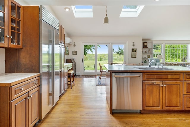576 W Main Rd, Little Compton, RI 02837 - kitchen featuring stainless steel appliances, a skylight, brown cabinetry, a sink, and healthy amount of natural light