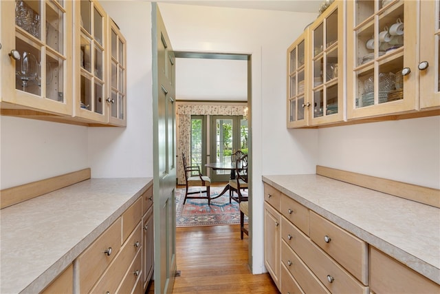 576 W Main Rd, Little Compton, RI 02837 - kitchen featuring light brown cabinetry, light wood-style floors, light countertops, and glass insert cabinets