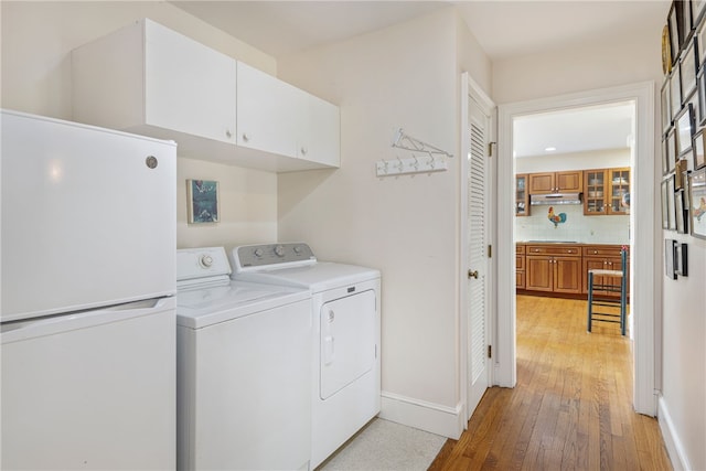 576 W Main Rd, Little Compton, RI 02837 - laundry area featuring cabinet space, washing machine and dryer, light wood-type flooring, and baseboards