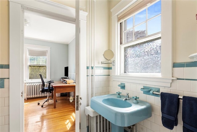 27 Cranston Ave, Newport, RI 02840 - bathroom with radiator, wood finished floors, tile walls, and a sink