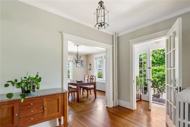 27 Cranston Ave, Newport, RI 02840 - entryway featuring radiator heating unit, a chandelier, crown molding, baseboards, and light wood-style floors