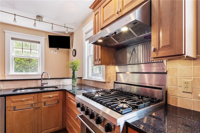 27 Cranston Ave, Newport, RI 02840 - kitchen with under cabinet range hood, a sink, high end stainless steel range oven, and brown cabinetry
