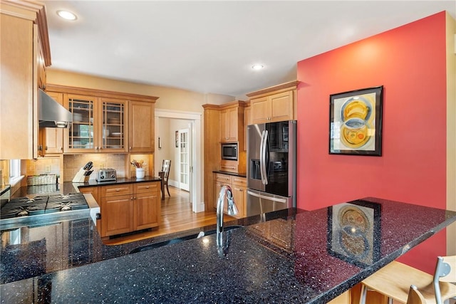 27 Cranston Ave, Newport, RI 02840 - kitchen featuring stainless steel appliances, under cabinet range hood, tasteful backsplash, glass insert cabinets, and a peninsula