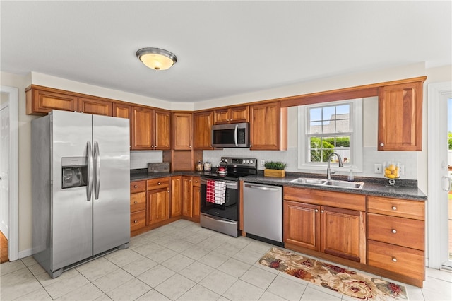 39 Exeter Blvd, Narragansett, RI 02882 - kitchen featuring appliances with stainless steel finishes, a sink, dark countertops, brown cabinetry, and light tile patterned floors