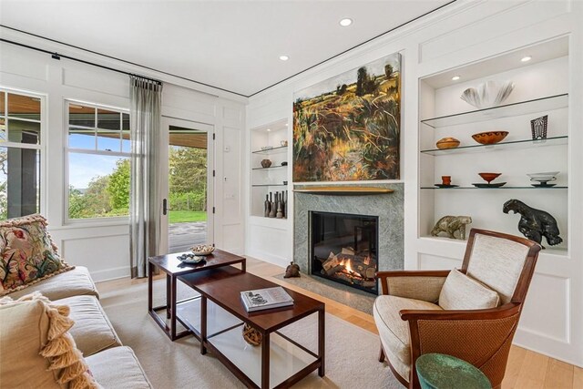 25 Walnut St, Jamestown, RI 02835 - living room with built in shelves, light wood-style flooring, a high end fireplace, recessed lighting, and ornamental molding