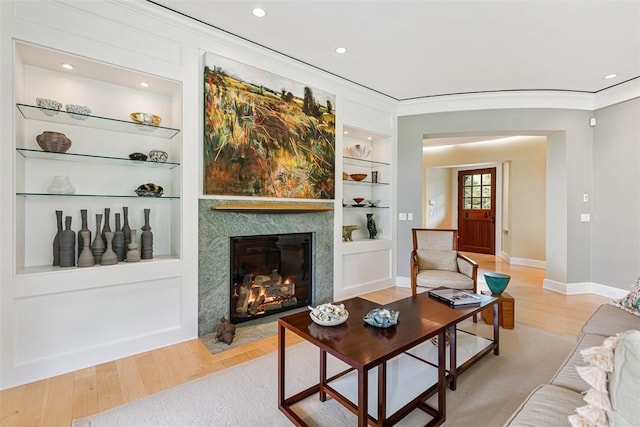25 Walnut St, Jamestown, RI 02835 - living area featuring built in shelves, a premium fireplace, baseboards, light wood finished floors, and crown molding