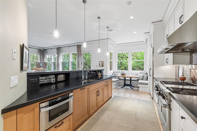 25 Walnut St, Jamestown, RI 02835 - kitchen featuring a sink, dark countertops, under cabinet range hood, recessed lighting, and decorative light fixtures