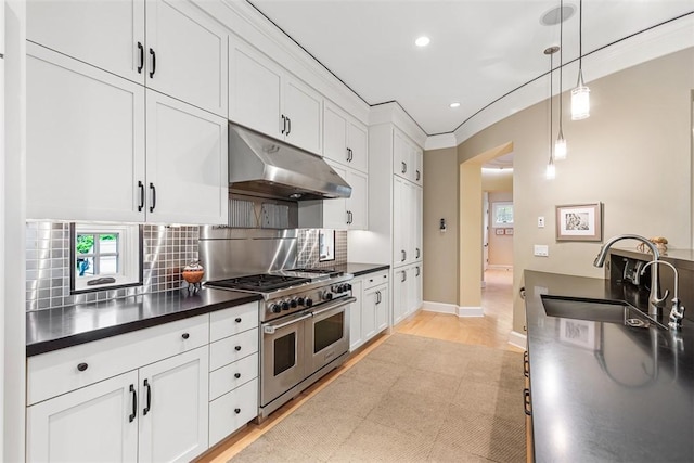25 Walnut St, Jamestown, RI 02835 - kitchen with a sink, under cabinet range hood, double oven range, dark countertops, and recessed lighting