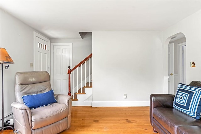 33 Upland Way, Barrington, RI 02806 - sitting room with light wood-style flooring, arched walkways, stairs, and a baseboard radiator