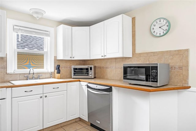 33 Upland Way, Barrington, RI 02806 - kitchen featuring appliances with stainless steel finishes, light countertops, tasteful backsplash, white cabinetry, and light tile patterned flooring