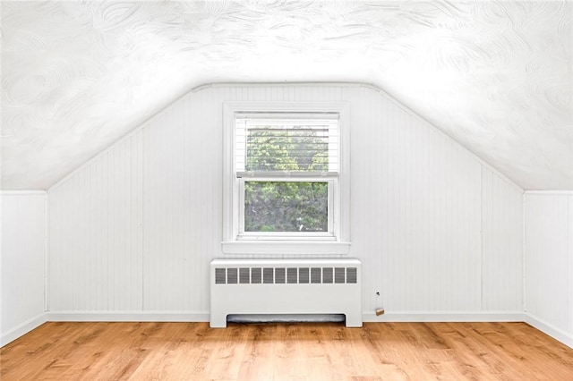 33 Upland Way, Barrington, RI 02806 - additional living space featuring radiator, lofted ceiling, wood finished floors, and a textured ceiling