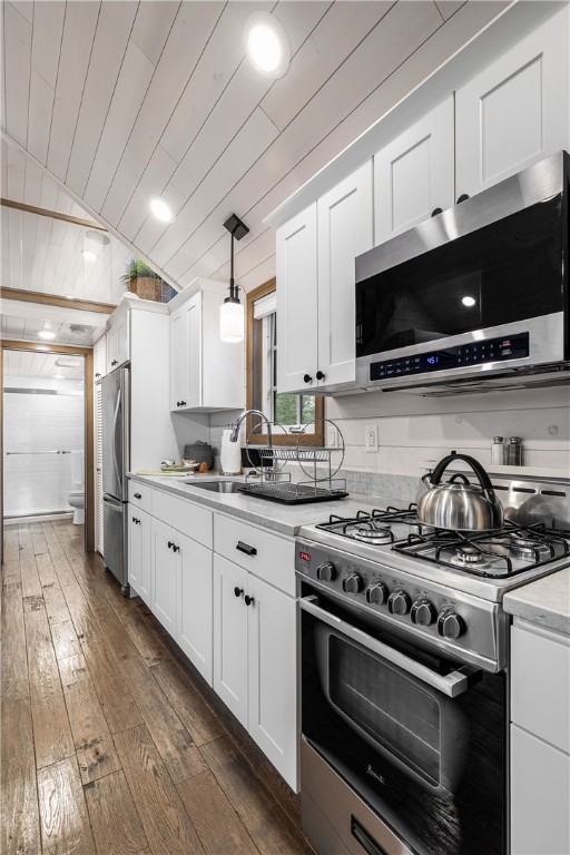 12 Alexander Cir Unit Th2, Richmond, RI 02898 - kitchen with appliances with stainless steel finishes, dark wood-type flooring, white cabinetry, lofted ceiling, and hanging light fixtures