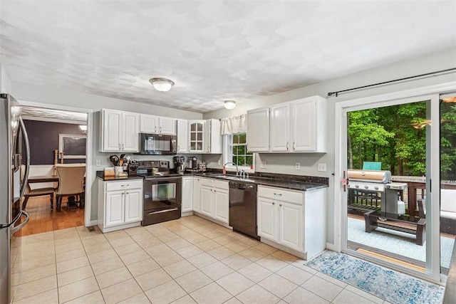 121 Greenbush Rd, Warwick, RI 02818 - kitchen with black appliances, white cabinets, light tile patterned floors, and a sink