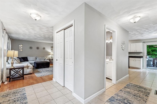 121 Greenbush Rd, Warwick, RI 02818 - hallway featuring light tile patterned floors, a sink, and baseboards
