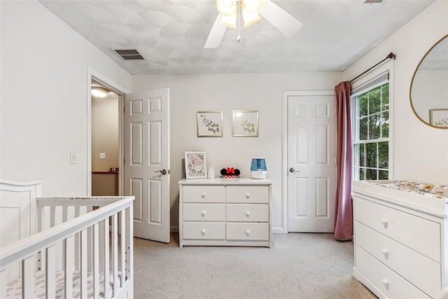121 Greenbush Rd, Warwick, RI 02818 - bedroom with light colored carpet, a crib, and ceiling fan