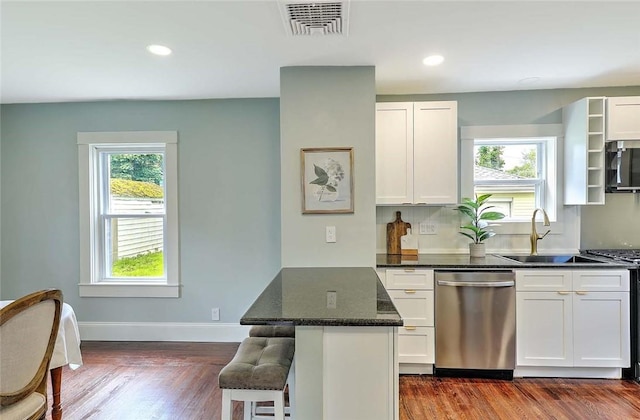 101 Knollwood Ave, Cranston, RI 02910 - kitchen featuring appliances with stainless steel finishes, a sink, white cabinetry, dark wood-style floors, and a breakfast bar area