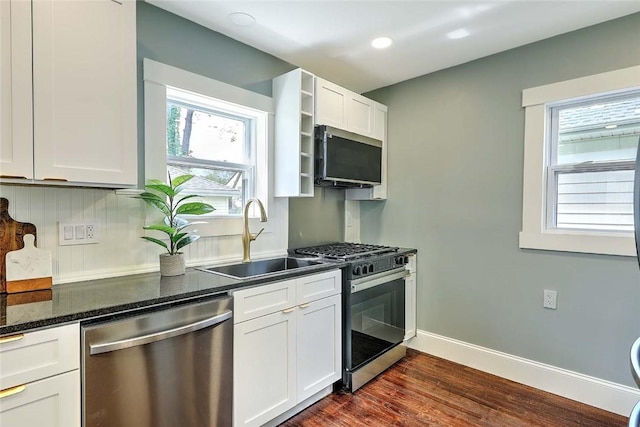 101 Knollwood Ave, Cranston, RI 02910 - kitchen with stainless steel appliances, a sink, dark wood-type flooring, white cabinets, and baseboards