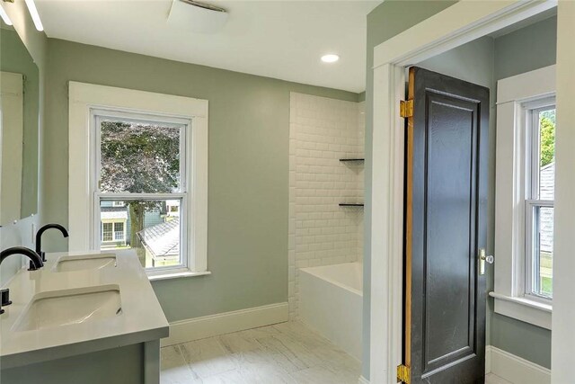 101 Knollwood Ave, Cranston, RI 02910 - bathroom featuring double vanity, marble look tiles, baseboards, recessed lighting, and bathing tub / shower combination