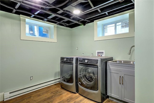 101 Knollwood Ave, Cranston, RI 02910 - washroom with a baseboard radiator, separate washer and dryer, light wood-type flooring, and cabinet space