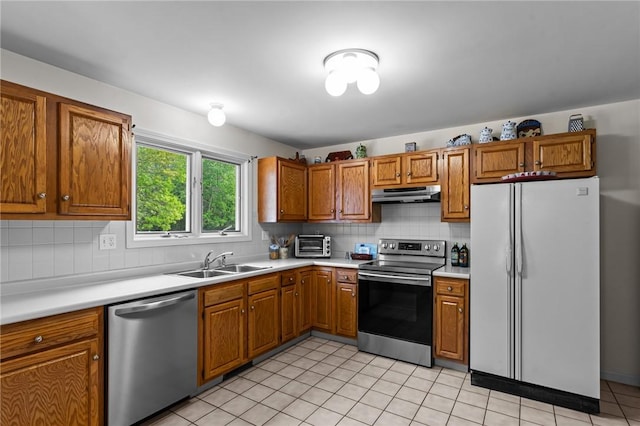 84 River Farms Dr Unit 84, West Warwick, RI 02893 - kitchen with appliances with stainless steel finishes, under cabinet range hood, a sink, light countertops, and brown cabinets